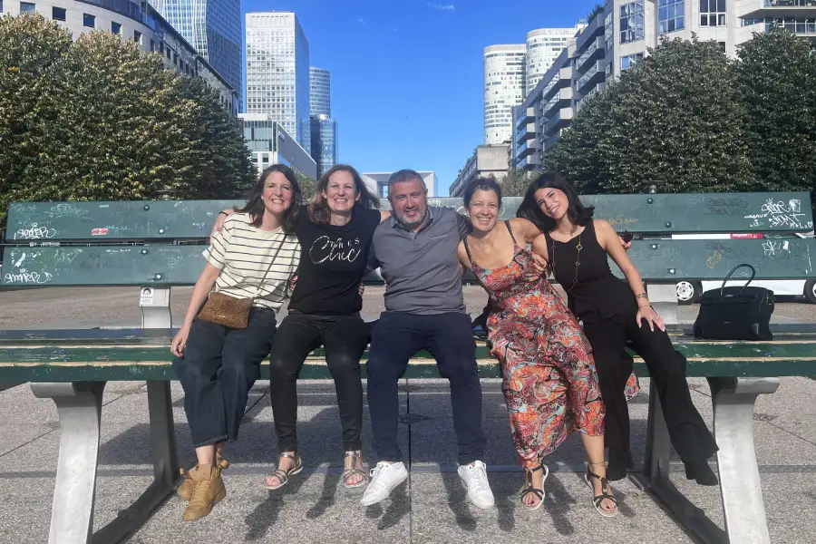 Équipe d'enquêteur durant l'escape game en extérieur à Paris La Défense. Assis sur le banc géant Les Extatiques.